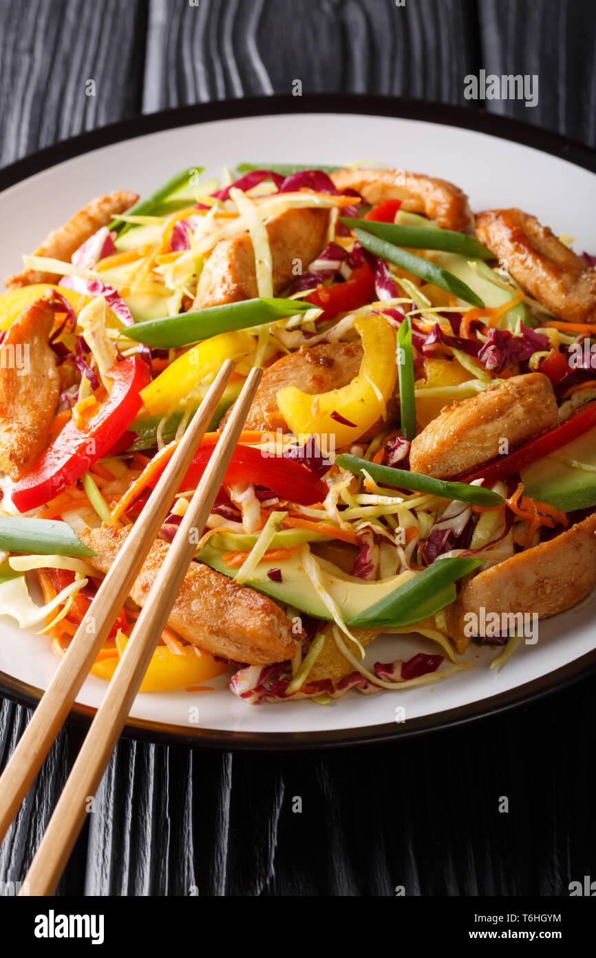 Deliziosa coleslaw con insalata di pollo, avocado e verdure close-up su una piastra sul piano verticale. Foto Stock