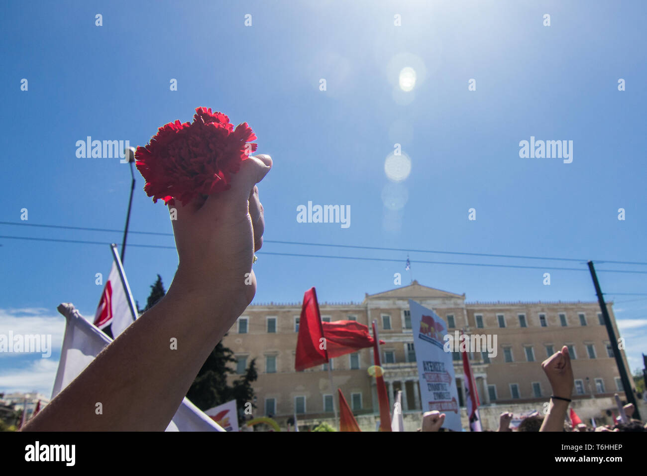 Atene, Grecia. 01 Maggio, 2019. Una ragazza si alza il suo pugno tenendo un garofano di fronte al palazzo del parlamento durante il mese di marzo. I sindacati marzo a causa del Labor Day celebrazione, in Atene Credito: Kostas Pikoulas/Pacific Press/Alamy Live News Foto Stock