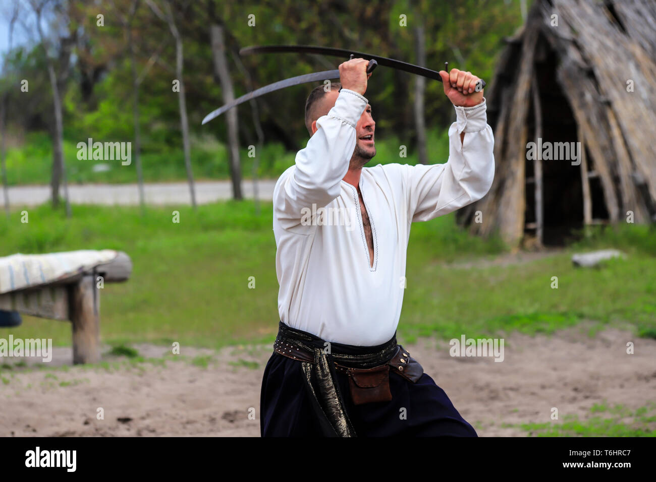 Petrikovka, Dnepropetrovsk regione, Ucraina, 28 04 2019. Un uomo mostra una serie di esercizi con sciabole al festival dei Cosacchi ucraini. Arti marziali, l'estate. Foto Stock
