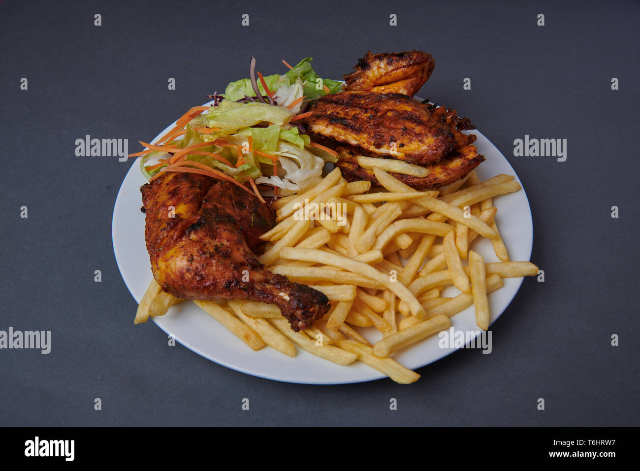 Grigliata di peri-peri pollo su uno sfondo grigio Foto Stock