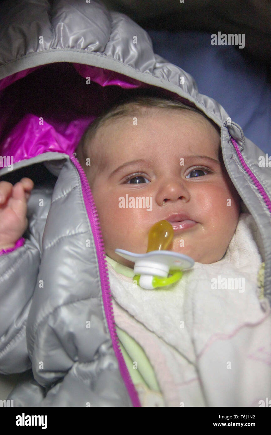 Ritratto di una incantevole piccola bambina nella camicia del bambino con il succhietto, Foto Stock