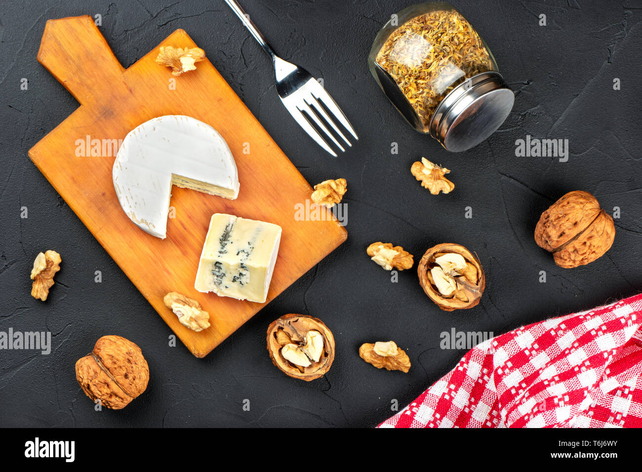 Formaggio Brie con fetta su un tagliere con noci, vista dall'alto Foto Stock