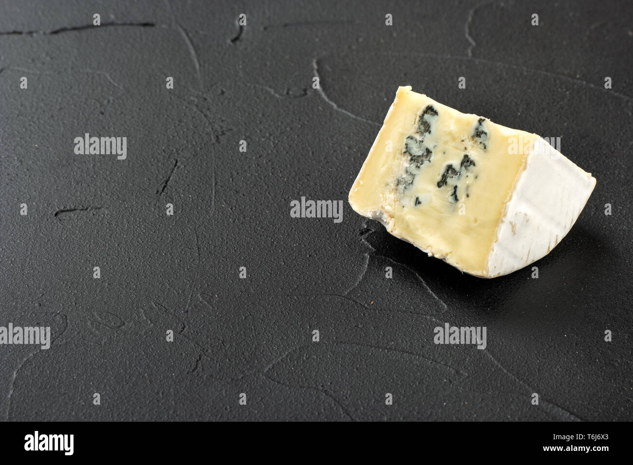 Fetta di formaggio brie con stampo su un vuoto di sfondo scuro Foto Stock