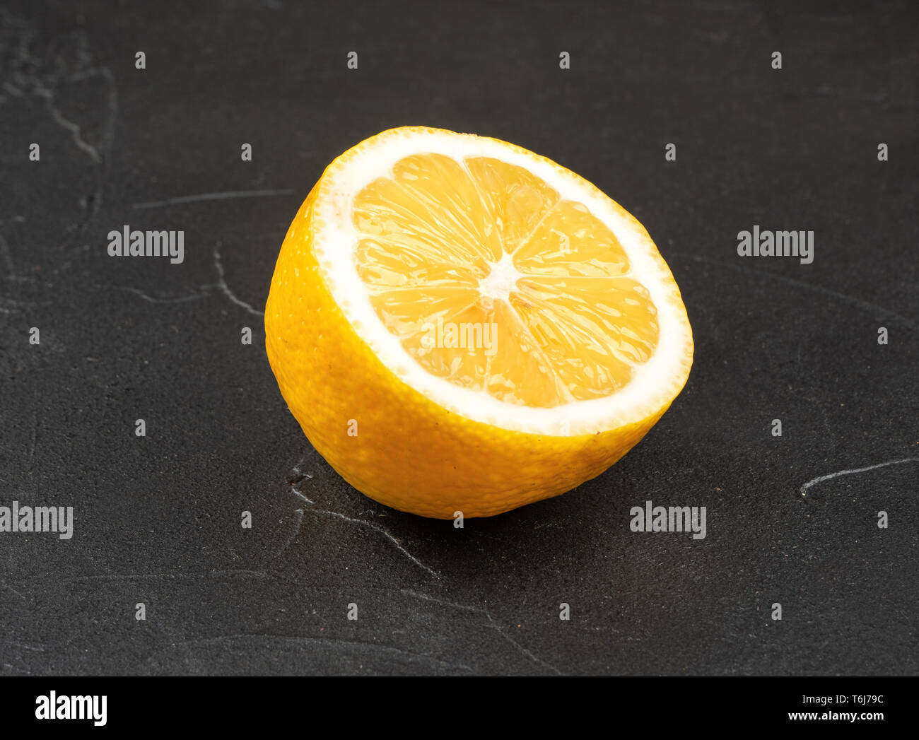Succosa metà limone su sfondo scuro Foto Stock