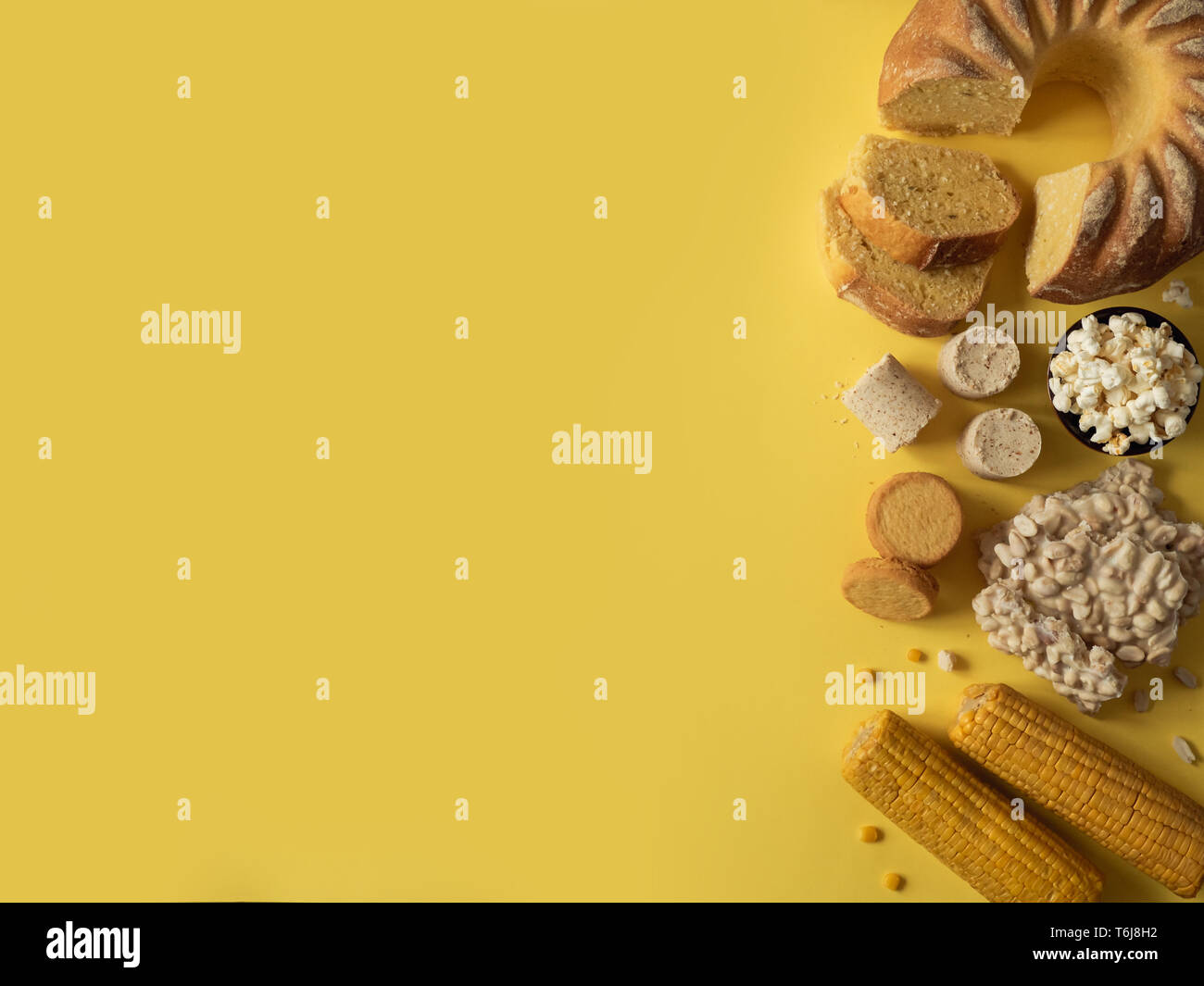 Festa Junina cibo tradizionale background,copia di spazio per il testo. Dolci deliziosi per brasiliano Festa Junina Party: Torta di farina di mais Bolo de Fuba, mais Biscotti,popcorn,peanut candy Pacoca, mais orecchio vista superiore Foto Stock