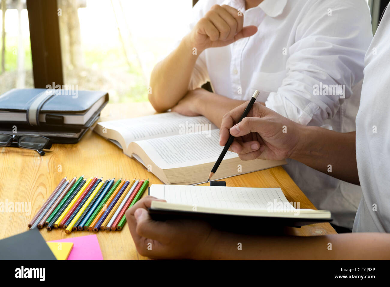 Gli studenti amico aiuta l insegnamento e l apprendimento oggetto ulteriori nella libreria. Il concetto di istruzione. Foto Stock