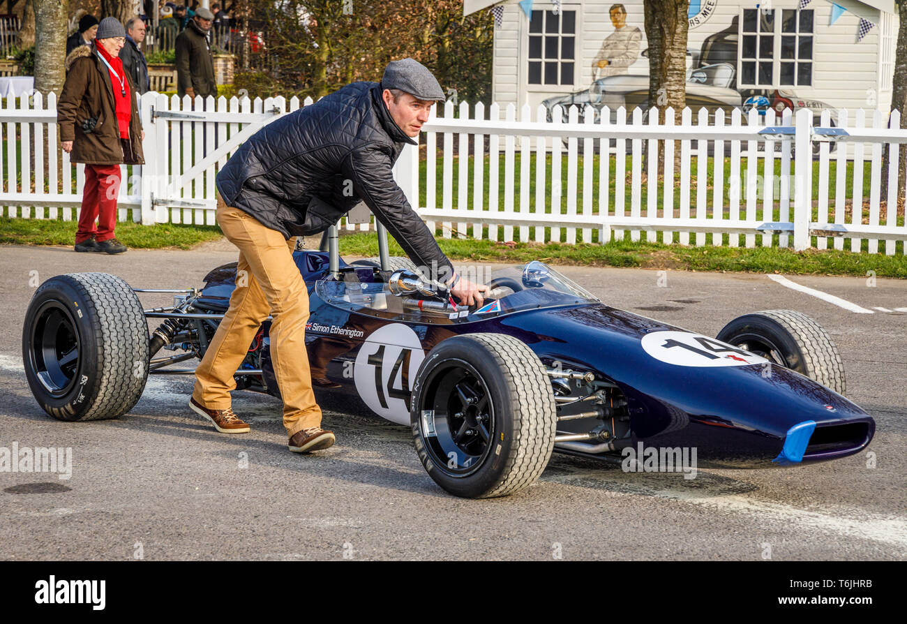 1965 Brabham-Ford BT15 è spinto nel paddock di contenimento prima di Derek Bell Cup gara al 77th Goodwood Assemblea dei Soci, Sussex, Regno Unito. Foto Stock