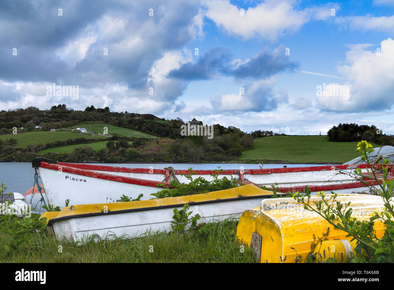 Capovolta barche in vetroresina sulla foreshore con una torre di castello in background. Foto Stock