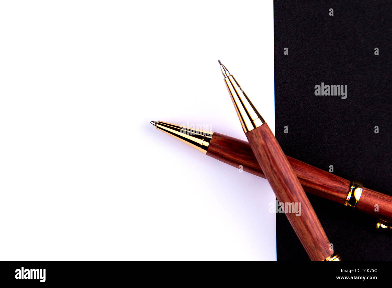 Il lusso di penna e matita meccanica in legno e oro con un foglio di carta bianco. Foto Stock