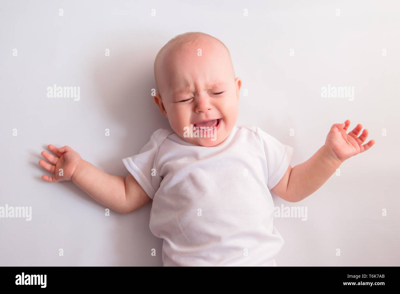 Il bambino piange su uno sfondo luminoso.Cry Baby Foto Stock