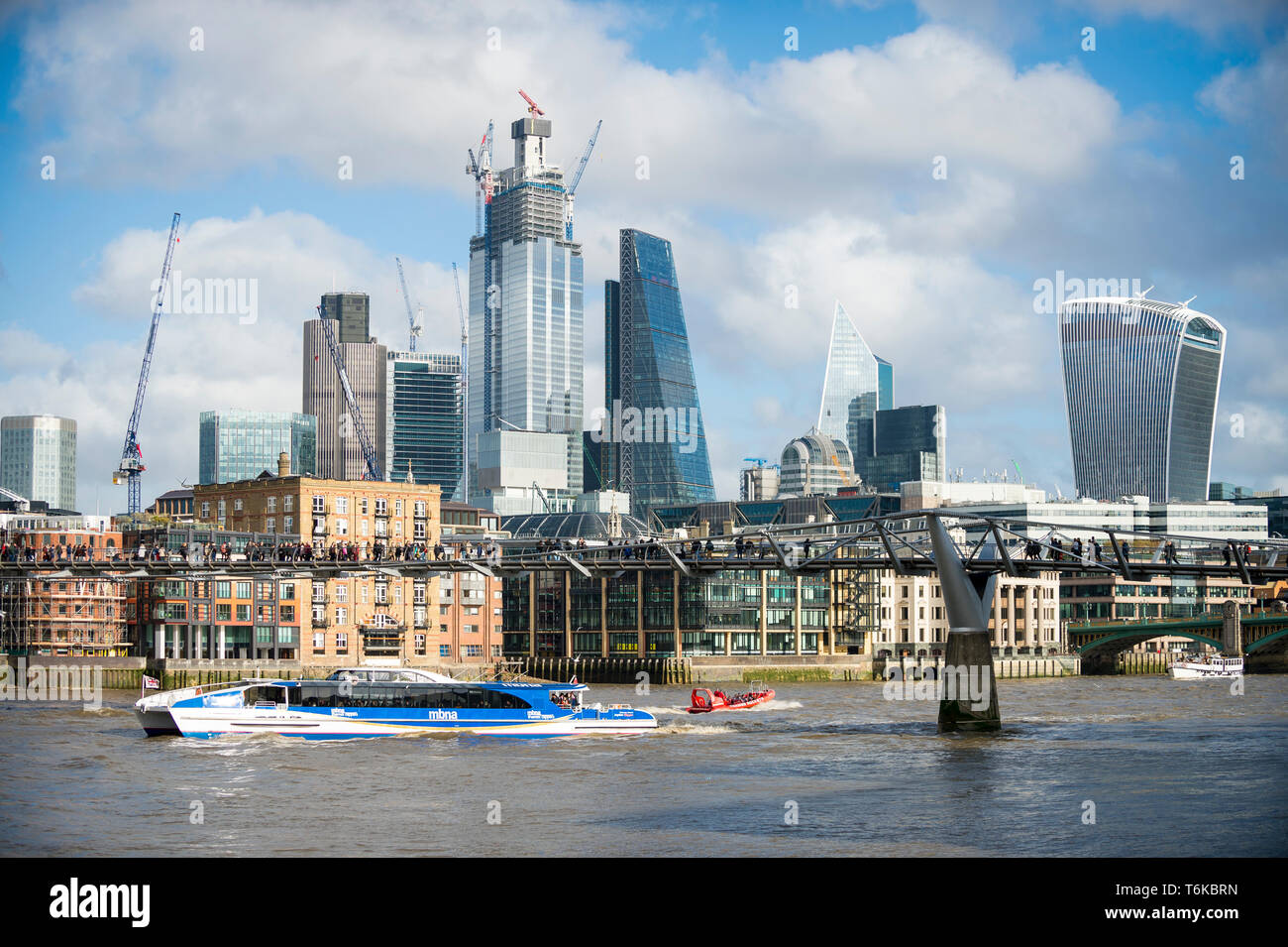 Londra - 10 novembre 2018: A Thames Clipper catamarano sponsorizzato da MBNA bank passa grattacieli in costruzione nel distretto finanziario. Foto Stock