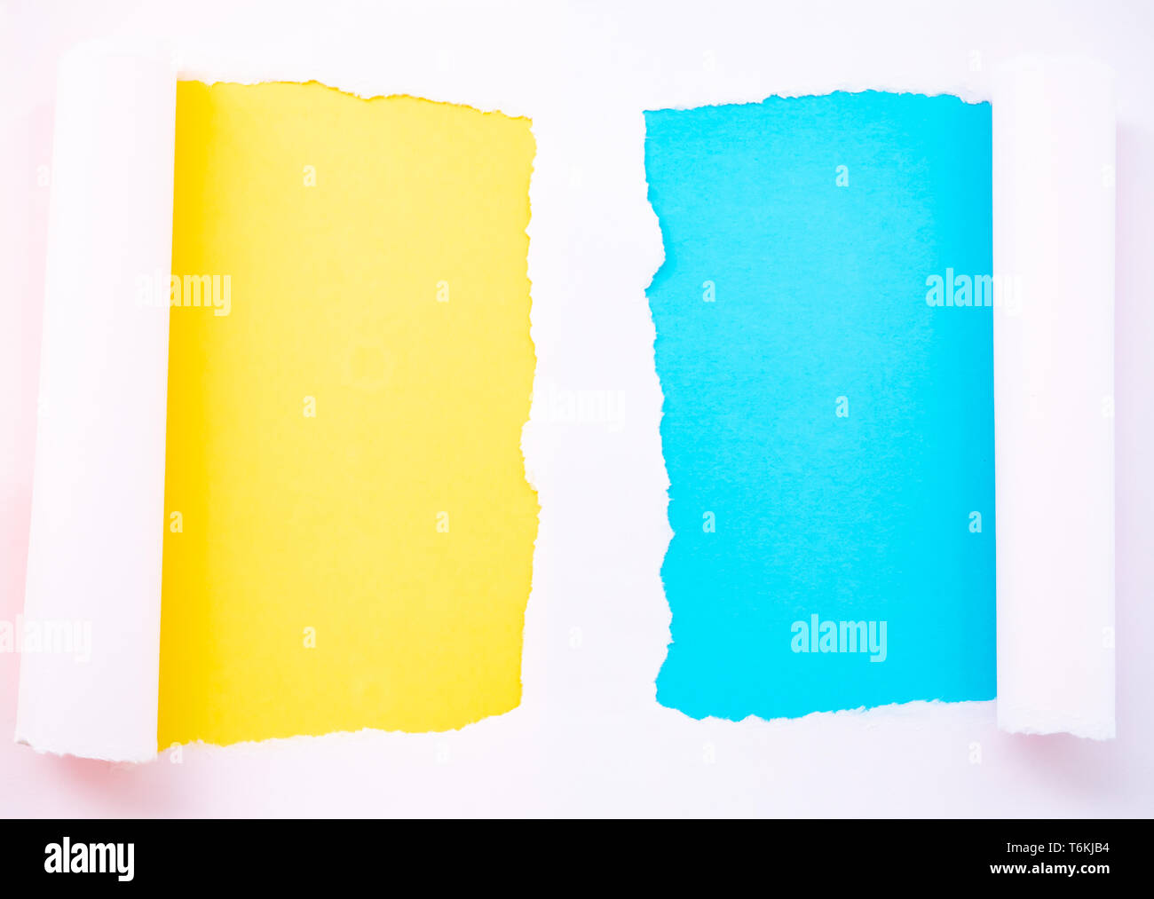 Strappata rosa pastello carta isolato in giallo e blu Foto Stock