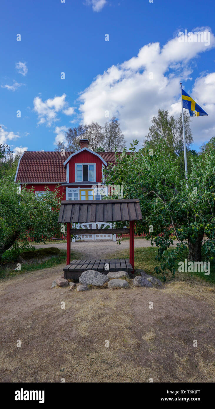 Vecchio carrello nella parte anteriore del rosso allevamento in legno casa sul cortile Katthult in Lönneberga, Schweden, Michel, Astrid Lindgren Foto Stock