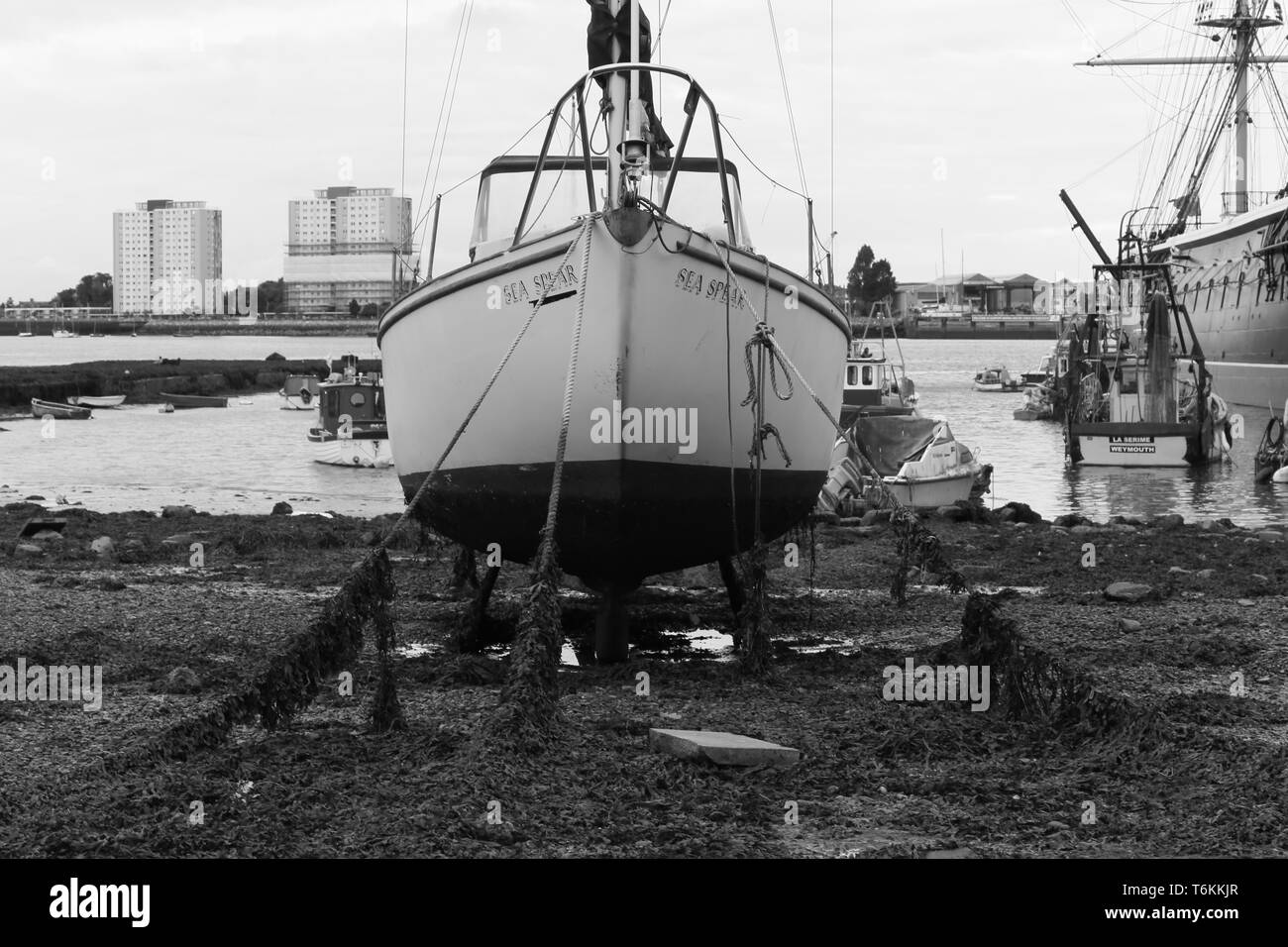 Imbarcazione a vela in Portsmouth Porto con la bassa marea. Portsmouth, Inghilterra. Regno Unito Foto Stock