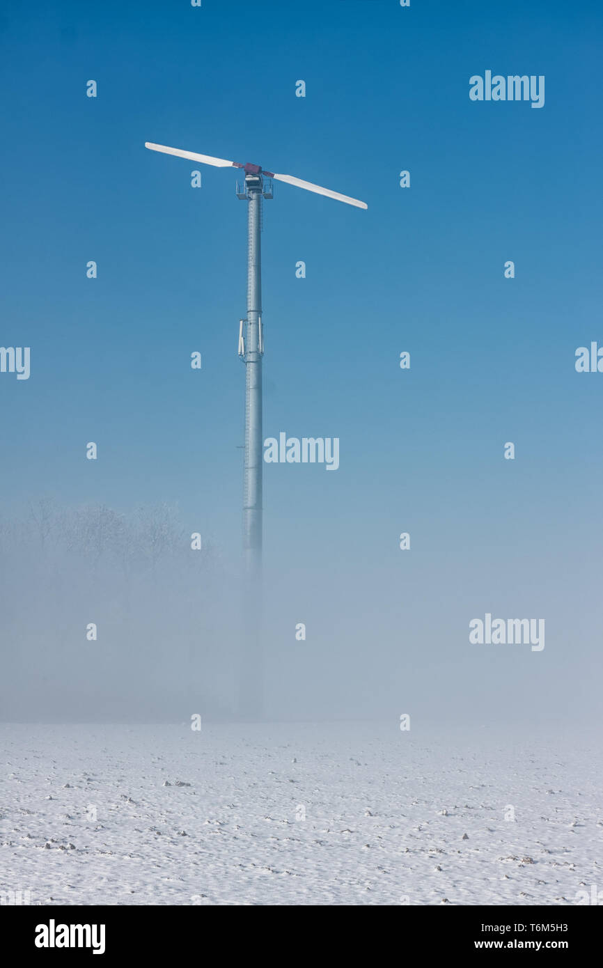Olandese paesaggio invernale con la terra della nebbia e la turbina eolica Foto Stock
