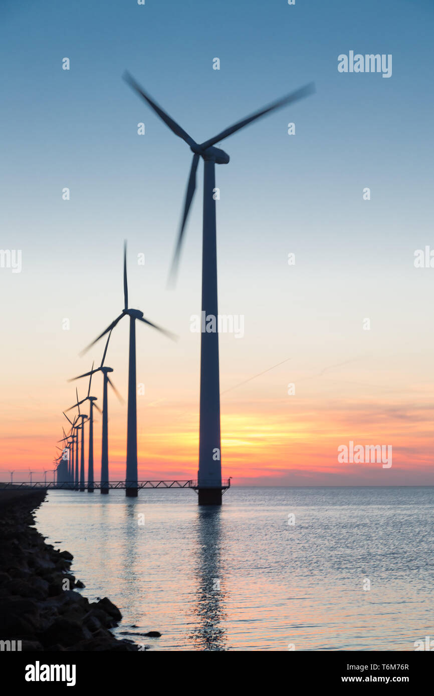 Riga olandese sulle turbine eoliche offshore in bel tramonto Foto Stock