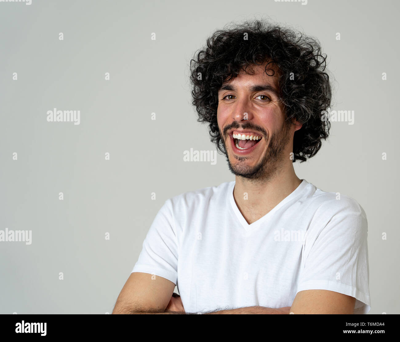 Ritratto di giovane attraente modello con faccia felice, sorriso bellissimo e divertente lo stile dei capelli. Bello millenaria l uomo nella sua 20s. Studio shot. In Persone, Foto Stock