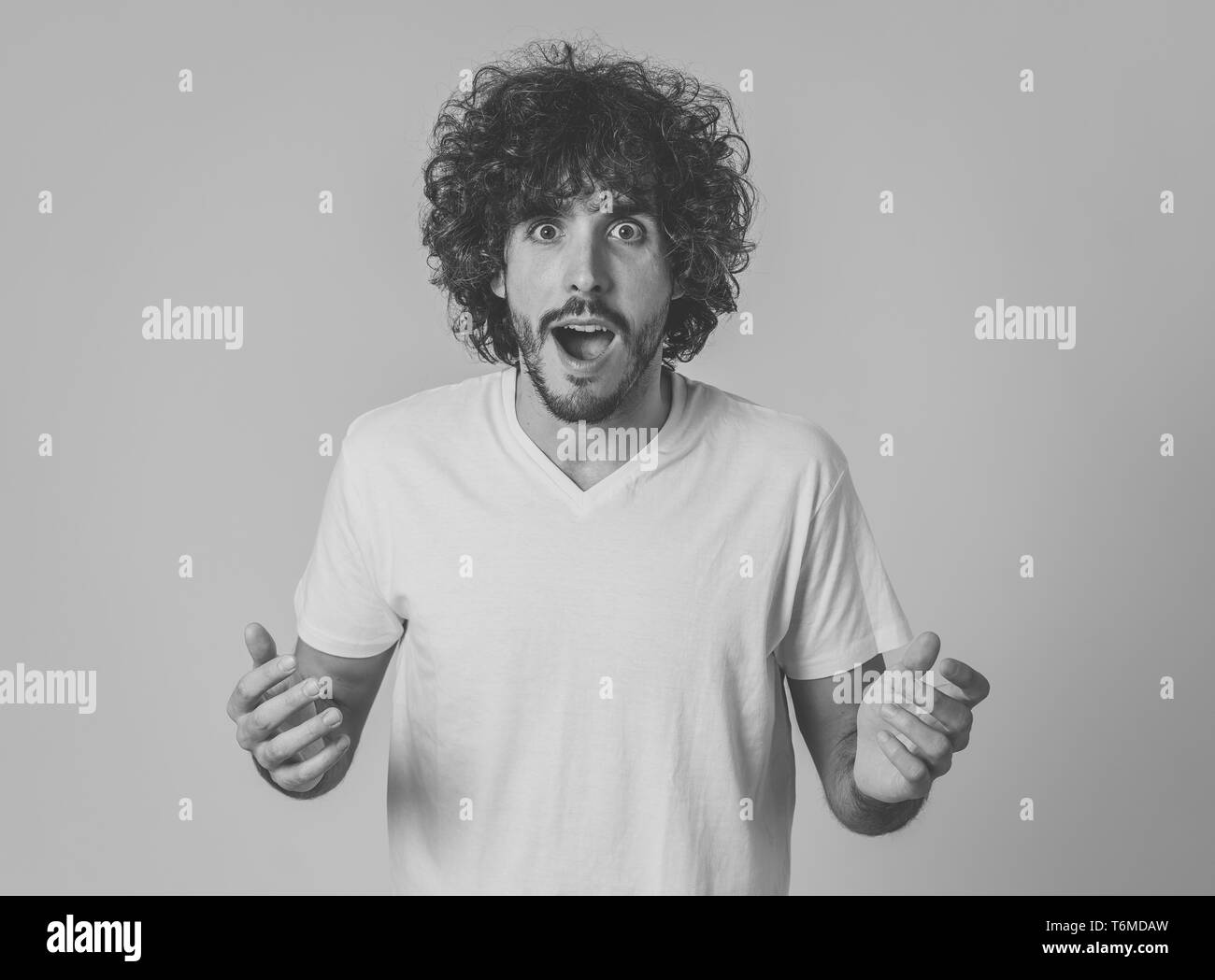 Ritratto di funny attraente giovane con felice e sorpreso faccia rivolta e guardando eccitati a qualcosa di terribile e buona. Le emozioni umane, faci Foto Stock