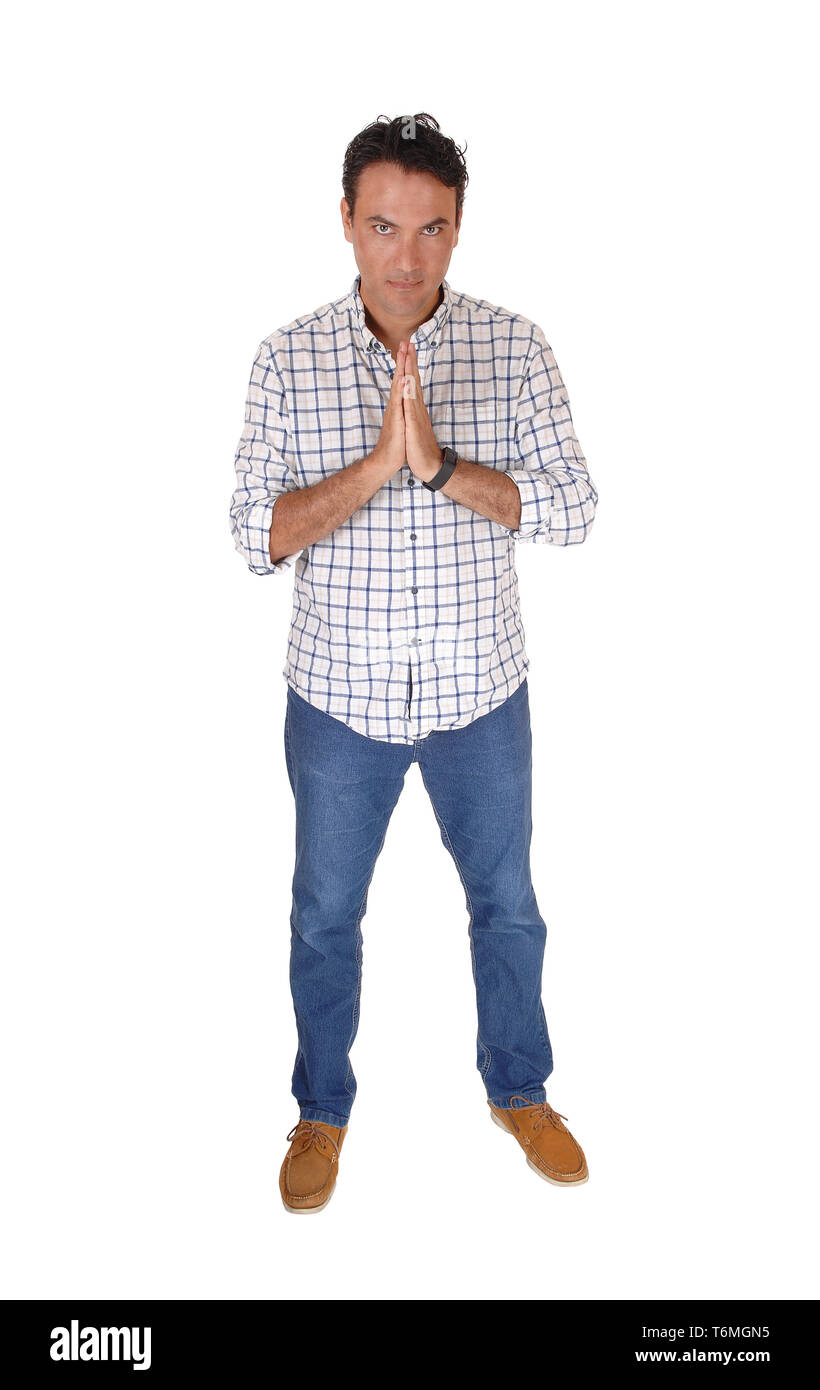 Giovane uomo che prega con le mani ripiegate, in piedi Foto Stock