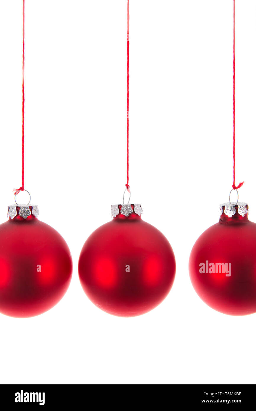 Appendere tre palle di Natale a uno sfondo bianco Foto Stock