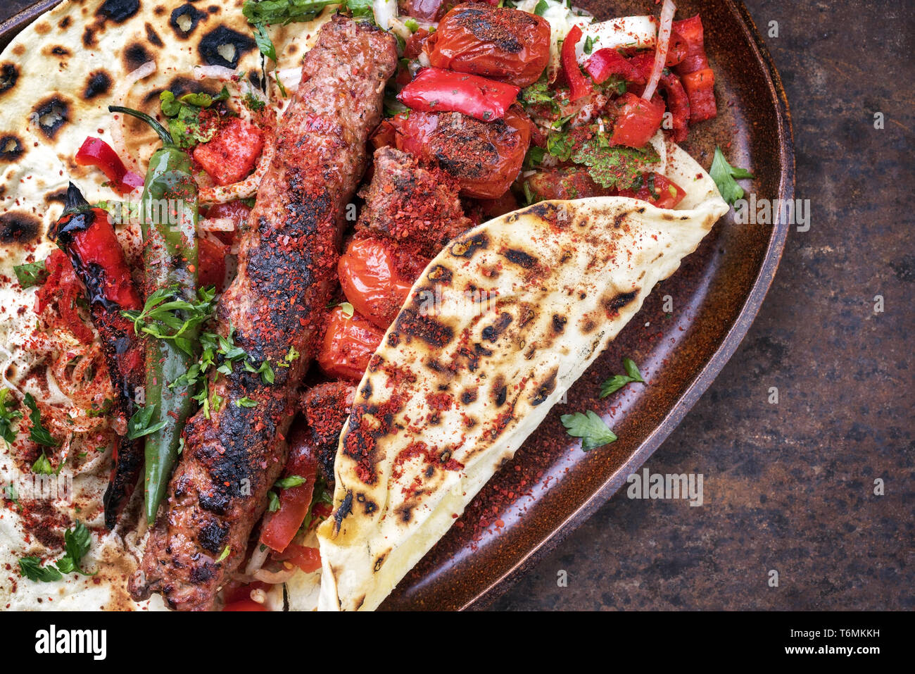 Tradizionali di Adana Kebap con pomodoro e insalata su un flatbread come close up Foto Stock