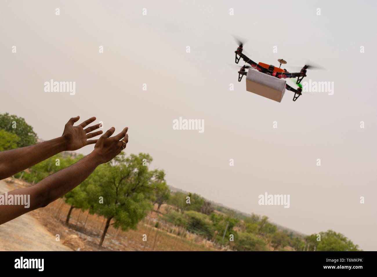 Assemblati Drone quadcopter offrendo un pacchetto e le mani il ricevimento del pacco Foto Stock