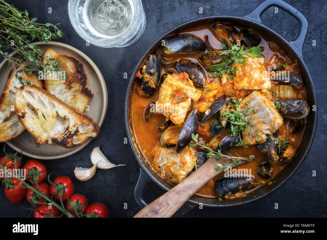 Tradizionale la Corsica francese stufato di pesce con cozze e aglio baguette come vista in pianta in un vaso Foto Stock