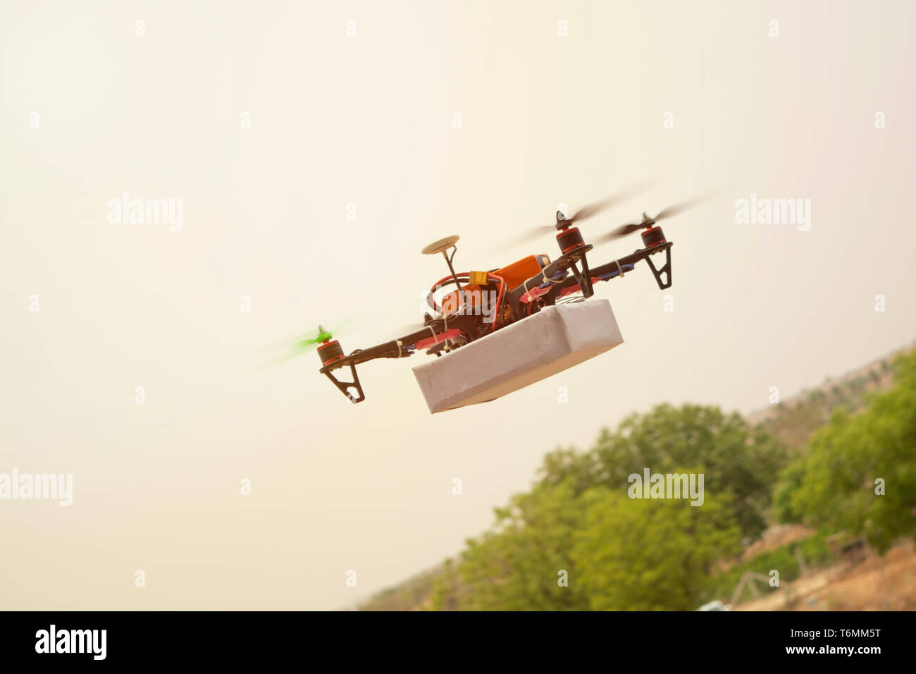 Concetto di assemblati Drone quadcopter offrendo un pacchetto Foto Stock