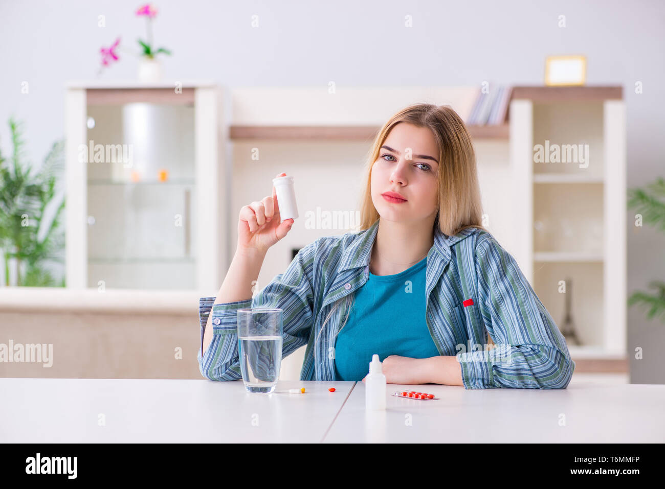 Donna di prendere le pillole per affrontare il dolore Foto Stock