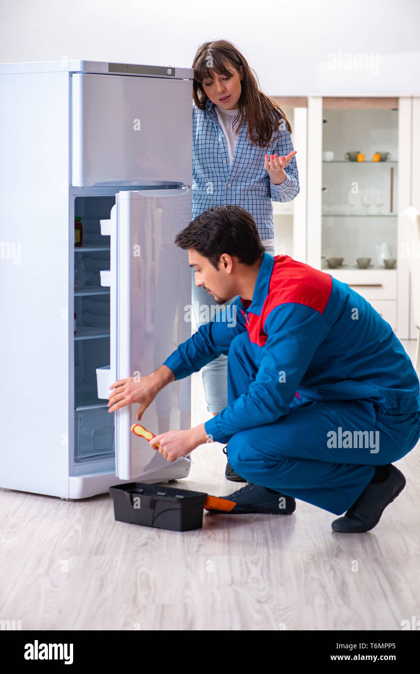 Uomo che ripara il frigorifero con il cliente Foto stock - Alamy