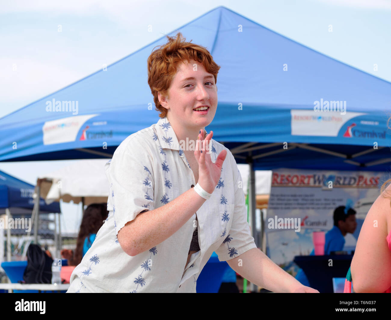 Un redheaded ragazza con lentiggini trattiene la sua mano come se per rifiutare una foto al 2019 Texas Sandfest in Port Aransas, Texas, Stati Uniti d'America. Foto Stock