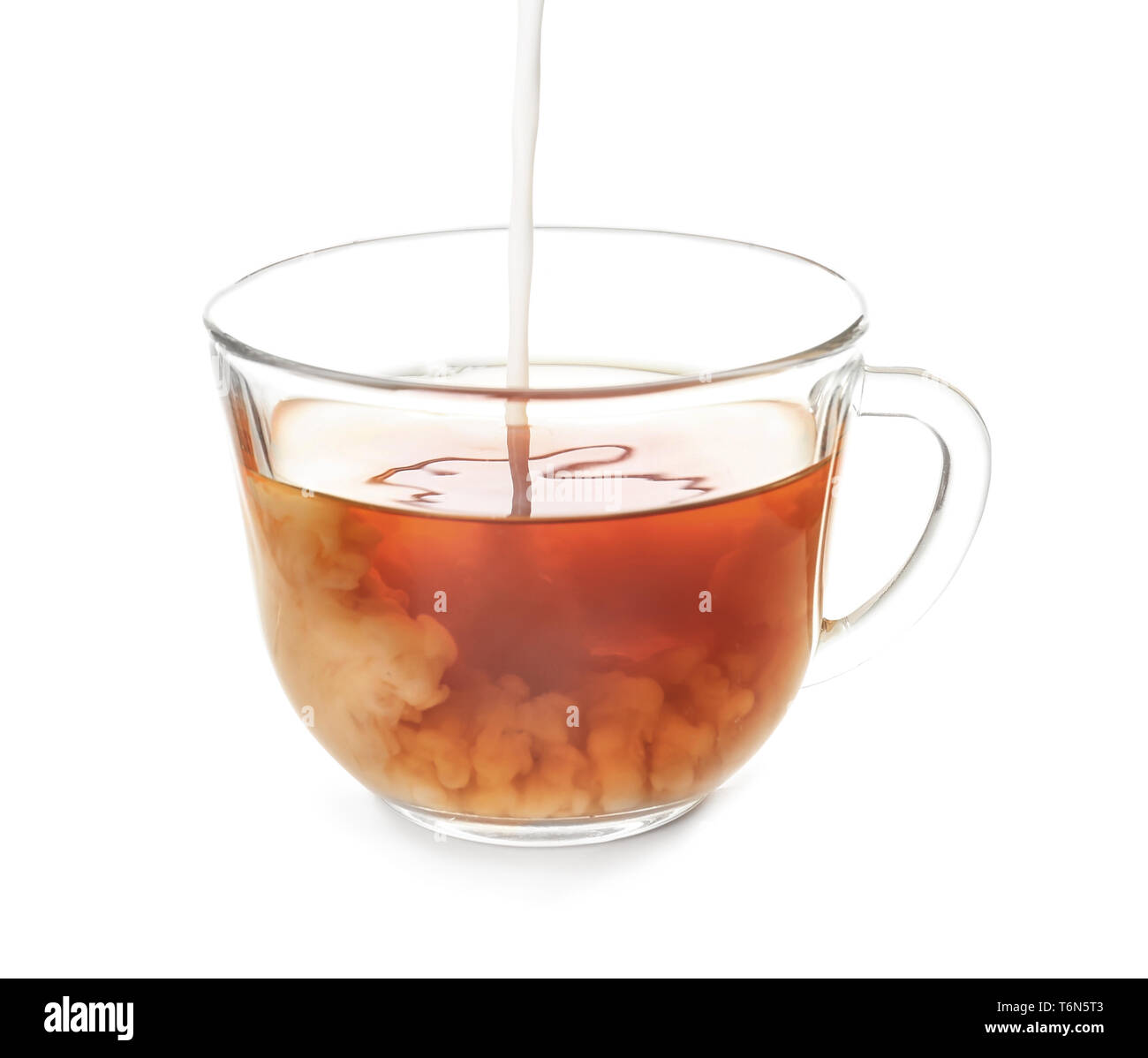 L'aggiunta di latte al tè delizioso su sfondo bianco Foto Stock