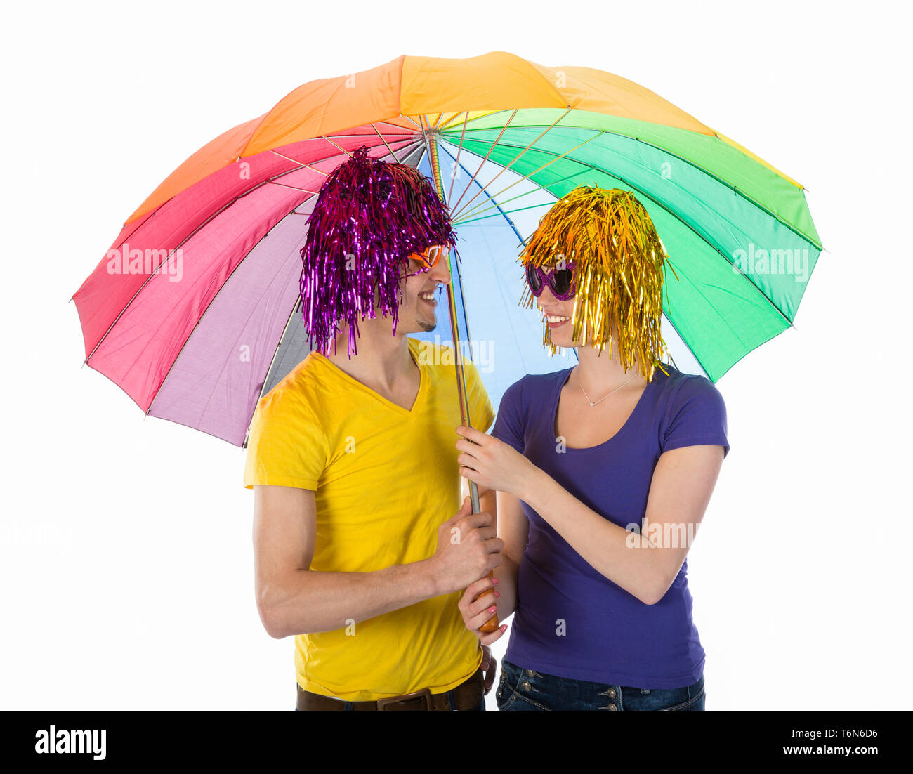 Funny giovane con le parrucche, occhiali da sole e ombrelloni Foto Stock