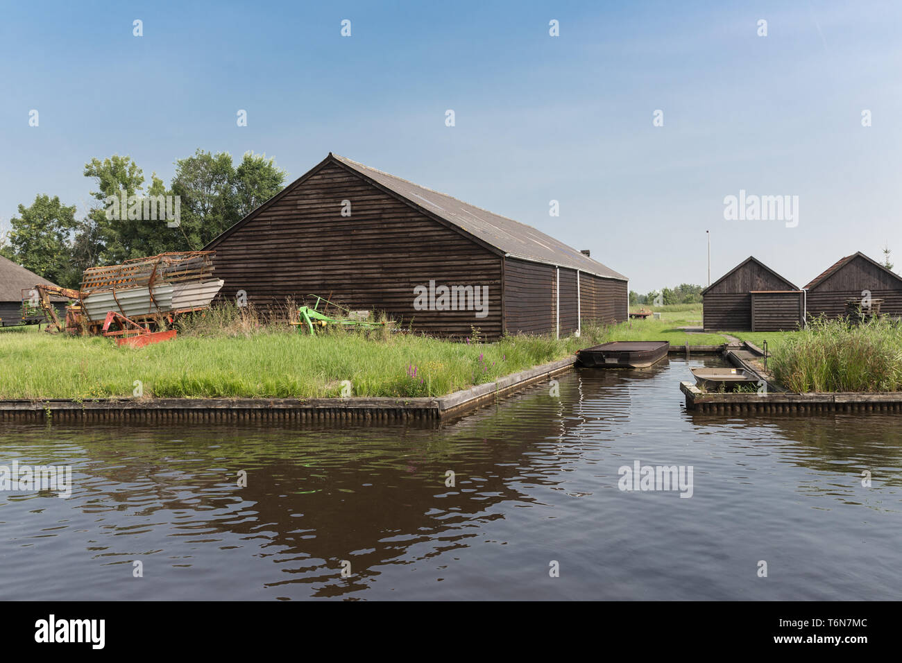 Old Dutch fienili in legno nei pressi di un canale Foto Stock