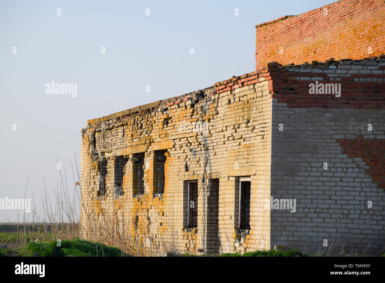 Vecchio mattone sovietica edificio abbandonato. Collassare costruzione in mattoni. Il bianco e il rosso mattone Foto Stock