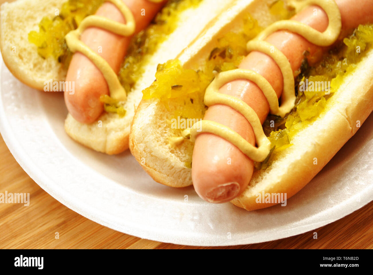 Hot Dogs con sapore e senape su una piastra bianca Foto Stock