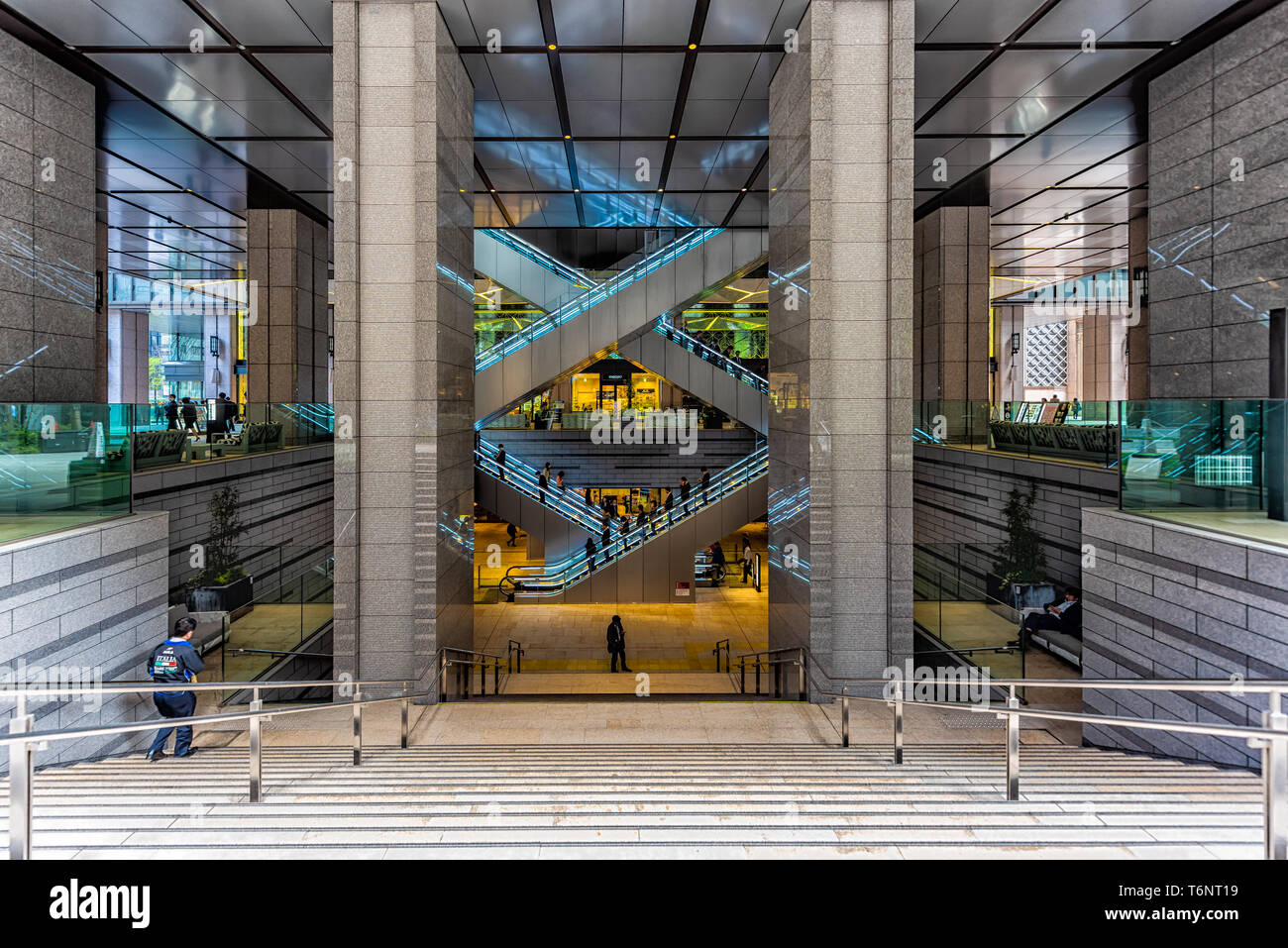 Tokyo, Giappone - 1 aprile 2019: Kyobashi Edopuland moderno centro affari edificio con architettura futuristica entrata di scale e scale mobili Foto Stock
