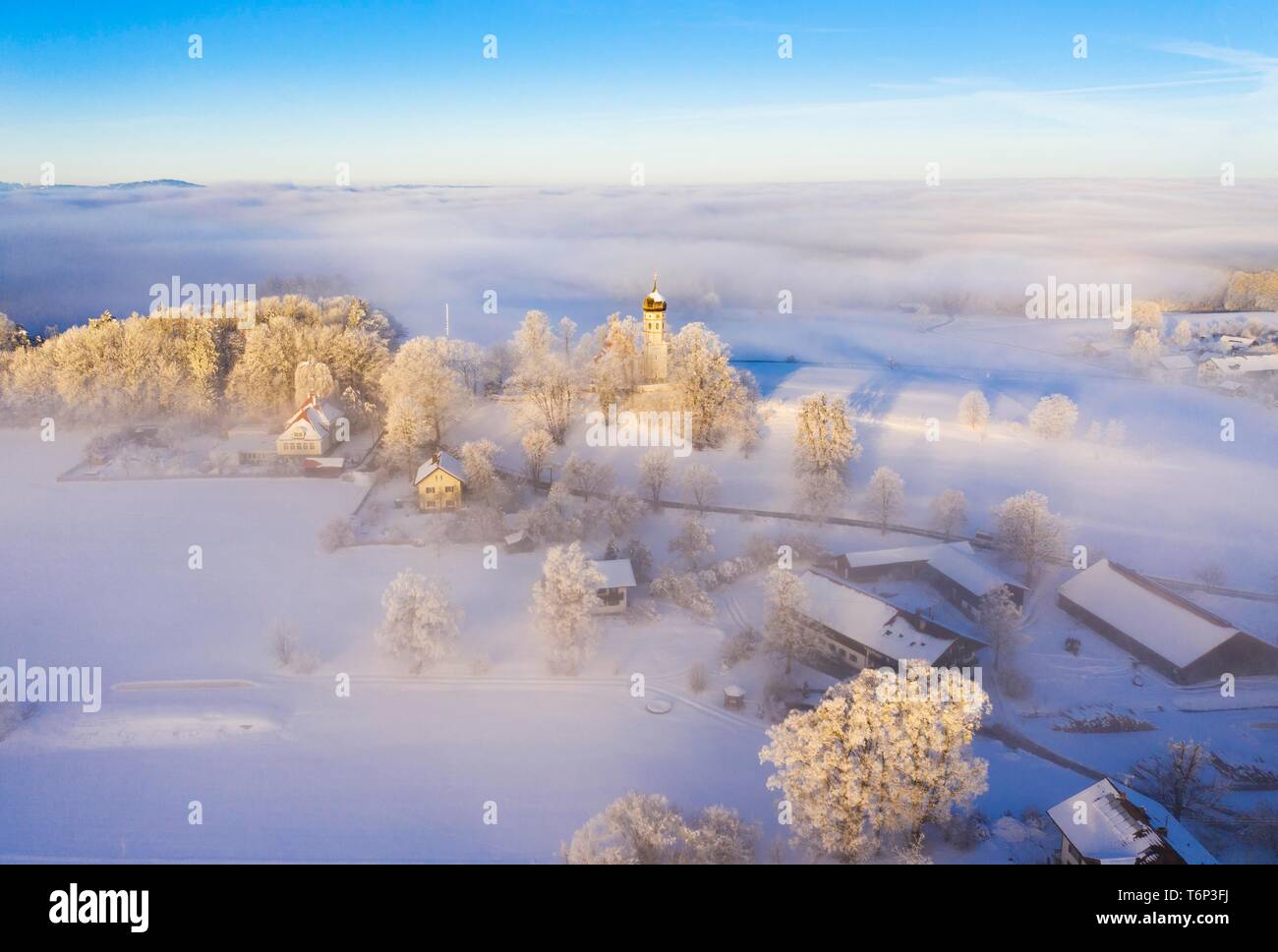 Paesaggio invernale, chiesa torre sorge dalla nebbia, Holzhausen, vicino Munsing, Funfseenland, drone shot, Alta Baviera, Baviera, Germania Foto Stock