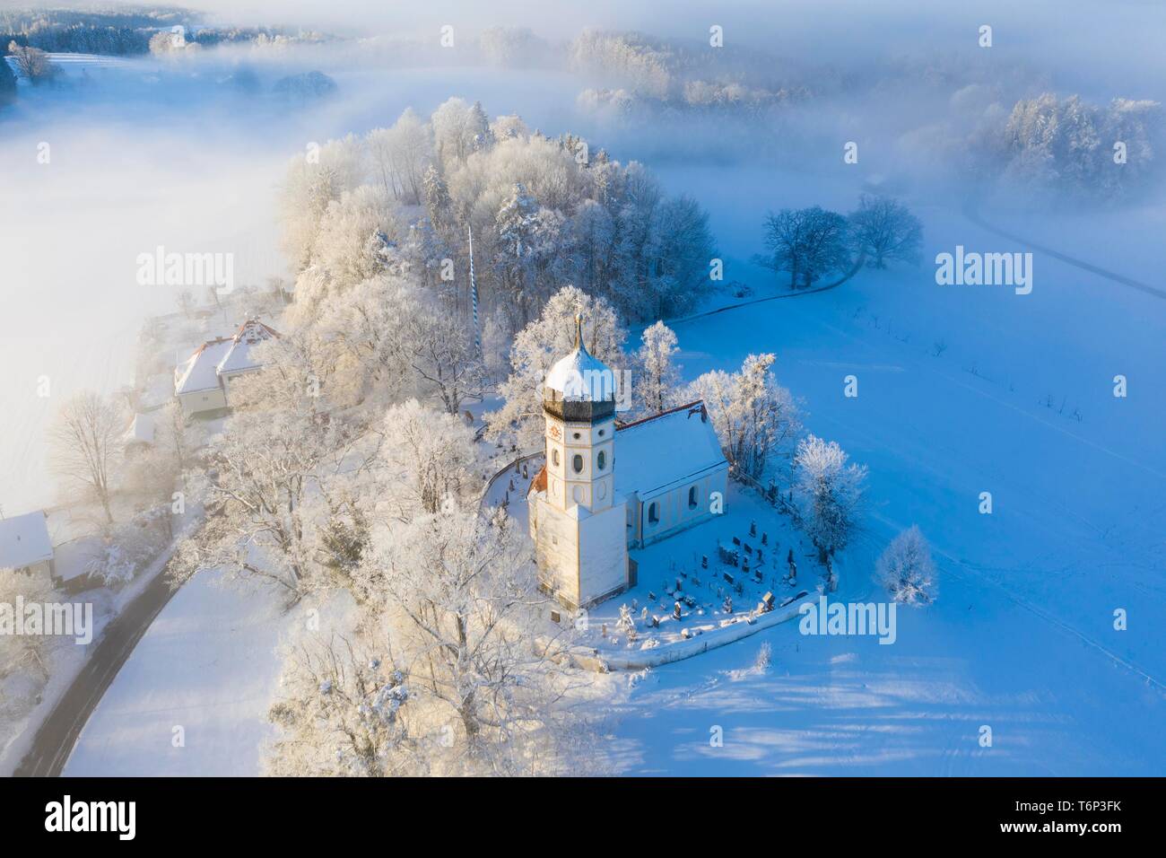 Coperte di neve chiesa St. Johann Baptist. Nebbia umore, Holzhausen vicino Munsing, Funfseenland, drone shot, Prealpi, Alta Baviera, Baviera Foto Stock
