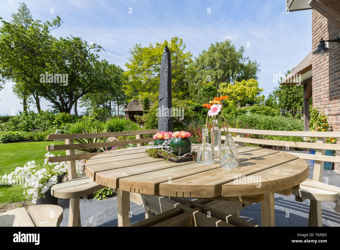 Giardino con panca in legno e tavolo Foto Stock