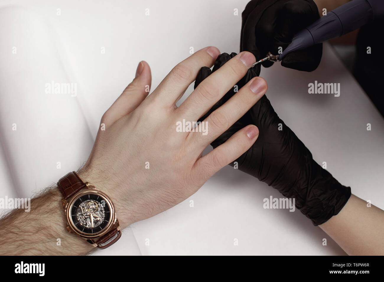 L'uomo sulle procedure nel salone di manicure. Spa, manicure, il master elabora chiodi il macinacaffè. Bel maschio di mani. Foto Stock