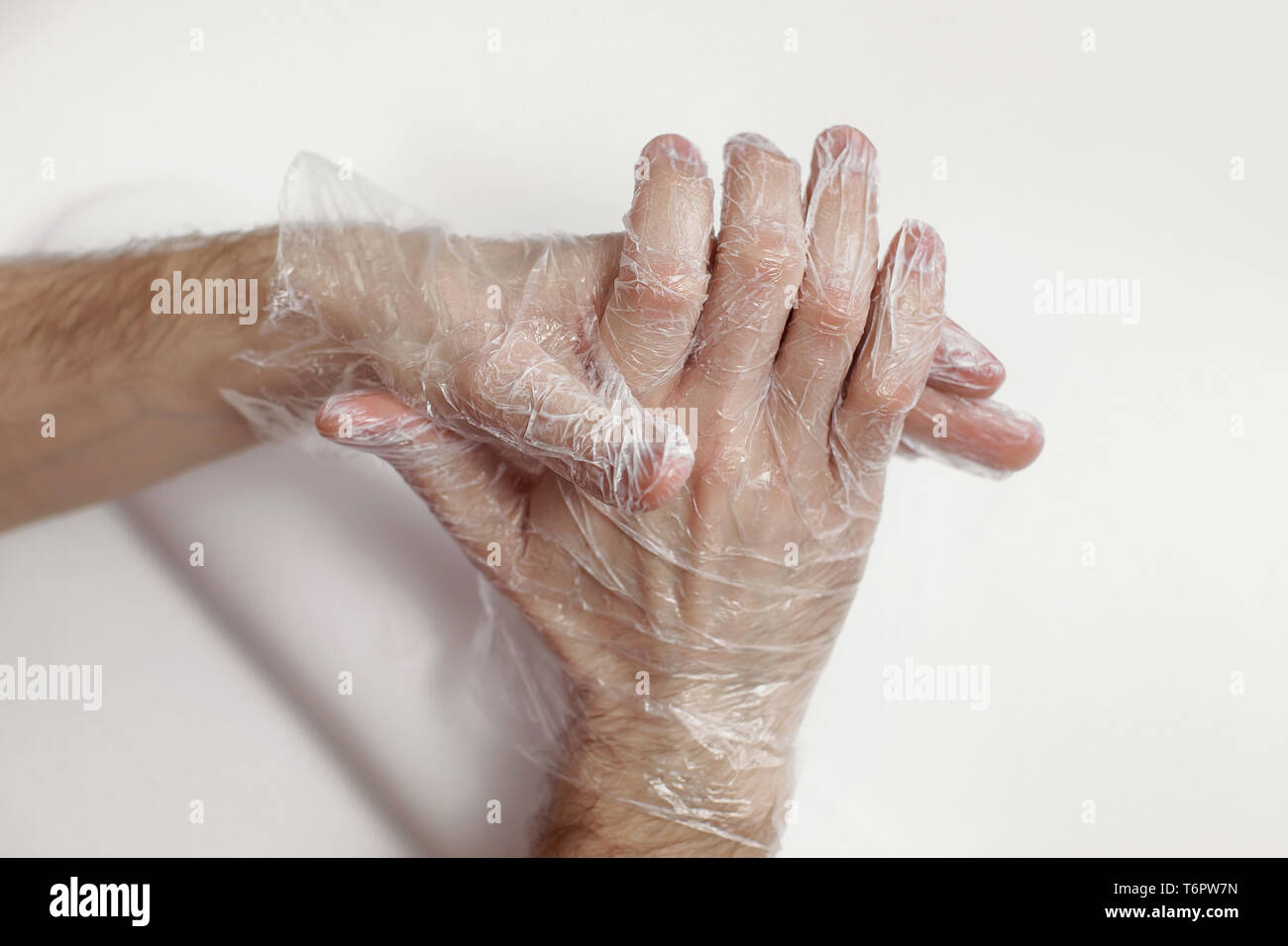 L'uomo fa il massaggio di mani per mezzo di una maschera - un guanto per le mani. Il nutriente, restoring cream. Bel maschio di mani. Foto Stock