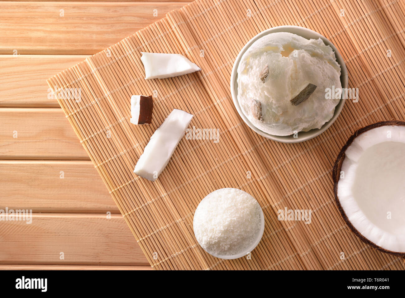 Il Cocco coppa di gelato decorata con noce di cocco rivestiti su una tavola di legno. Composizione orizzontale. Vista dall'alto. Foto Stock