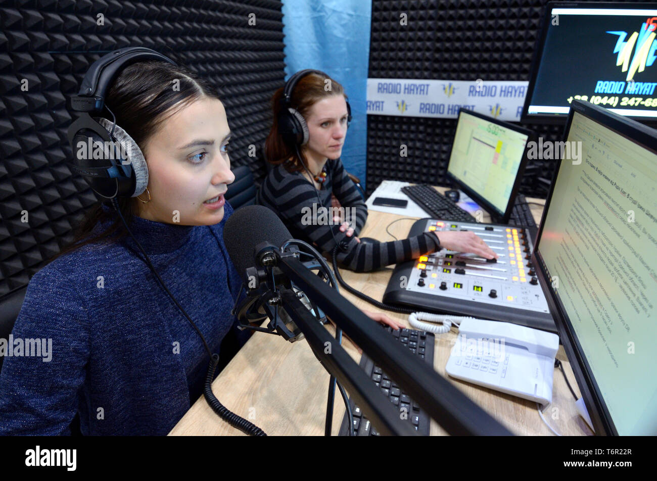 Il giornalista seduto davanti a un computer e la diffusione in uno studio radio durante la maratona di radio Radio al giorno. Il 3 gennaio 2018. A Kiev, Ucraina Foto Stock