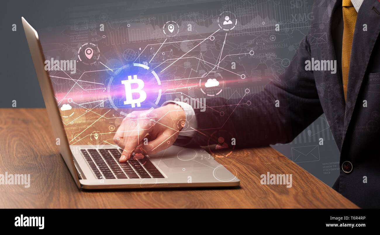 Controllare a mano sul laptop bitcoin globale Tasso di cambio concept Foto Stock