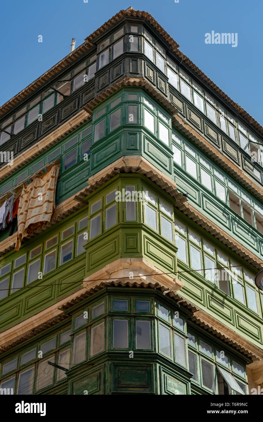 Tradizionali balconi Maltese (galleriji) stack sulla parte superiore di ogni altro ad un blocco di appartamenti in corrispondenza di un angolo della repubblica e strade del Nord Foto Stock