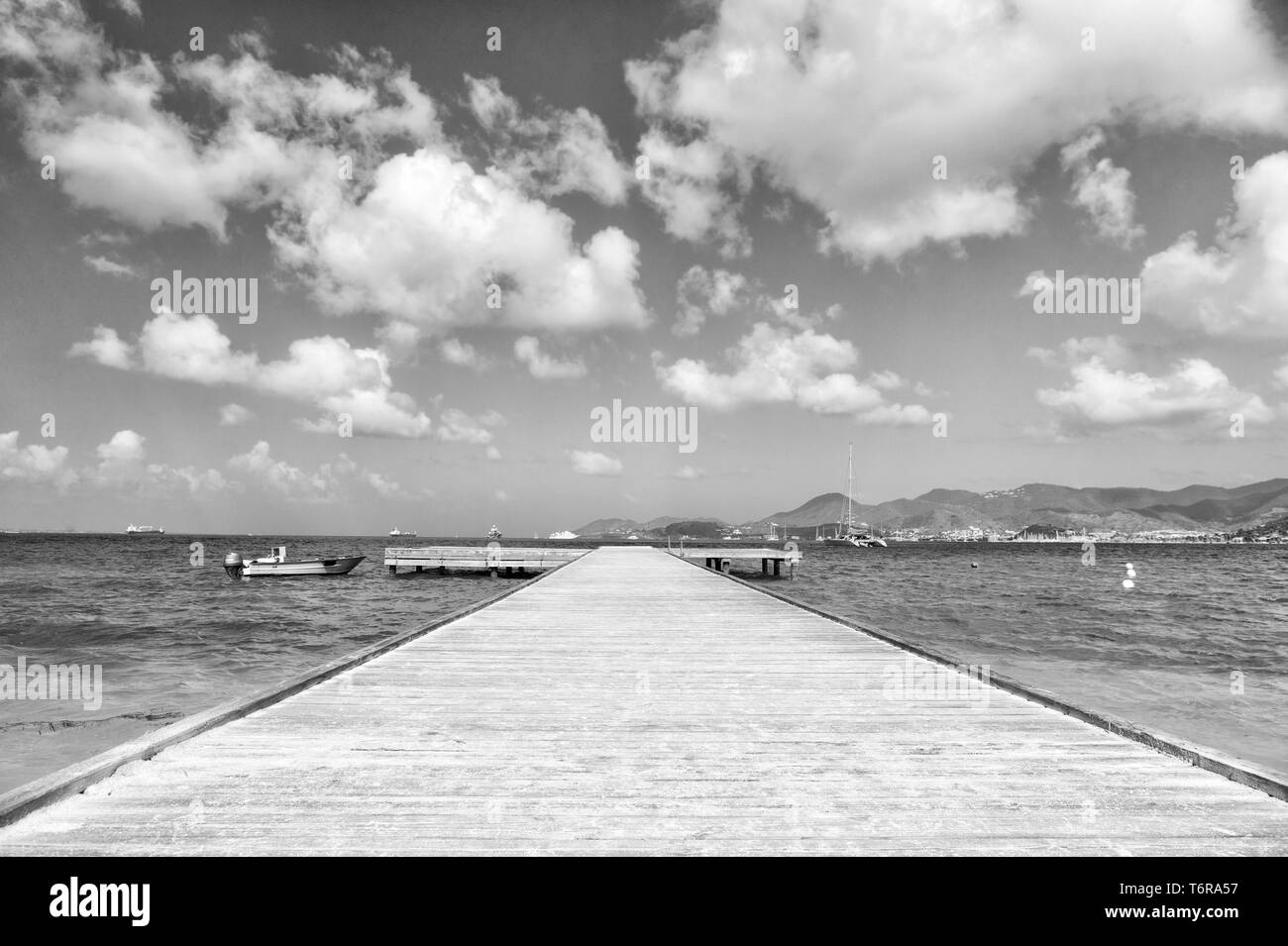 Bella marine dock con percorso di legno porto e le barche il trasporto su acqua estiva soleggiata outdoor su nuvoloso cielo blu sullo sfondo Foto Stock