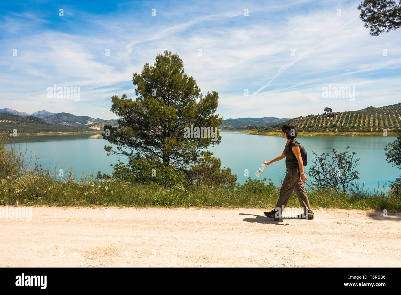 Donna escursionismo a Embalse de Iznájar, Iznajar lago circondato da uliveti e boschi di pini, in provincia di Cordoba, Andalusia. Foto Stock