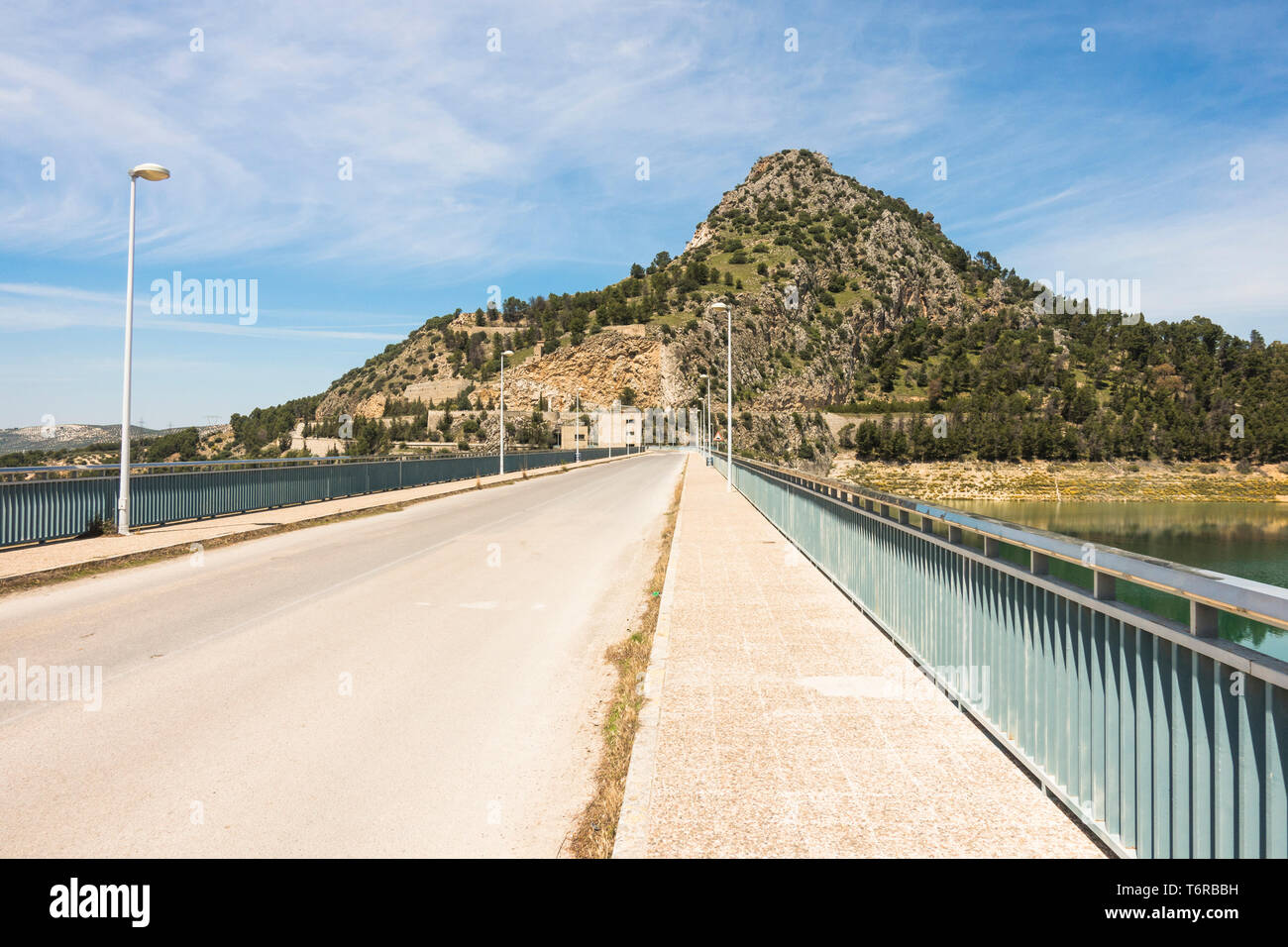 Strada sopra la diga a Iznajar serbatoio, del fiume Geníl, la fornitura di energia elettrica, in provincia di Cordoba, Spagna. Foto Stock