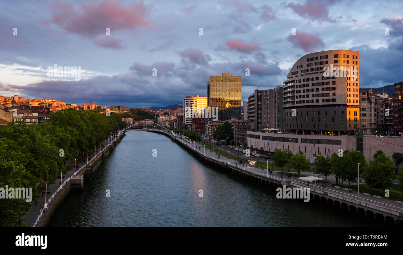 Bilbao riverside nelle vicinanze del Museo Guggenheim durante il tramonto, vista da La Salve bridge. Ponte Calatrava Foto Stock